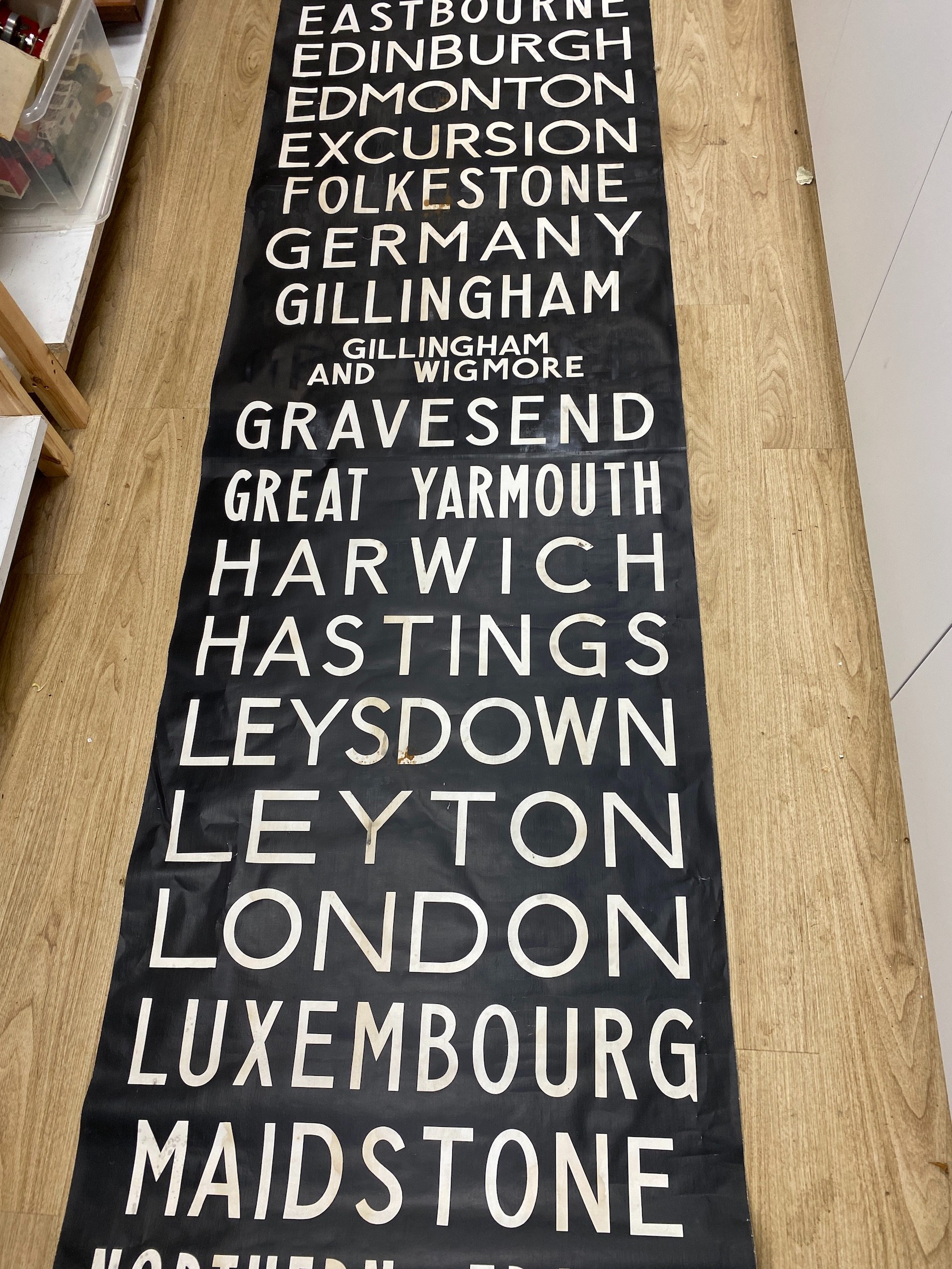 A painted canvas alphabetical list of European destinations including Sussex areas such as Brighton approximately 695x80cm